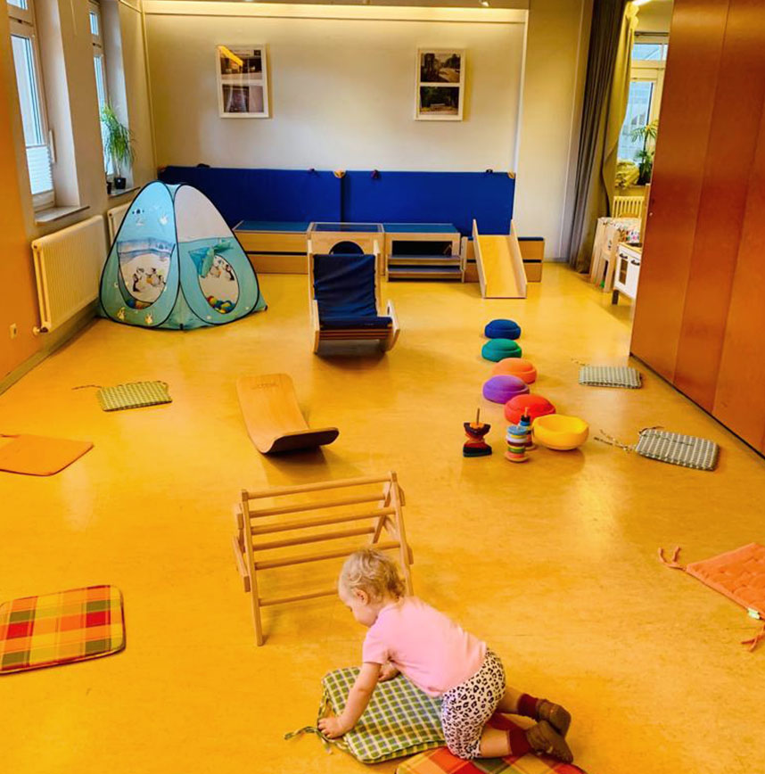Bewegungsraum mit Spielgeräten, Bälle-Zelt und kleinem Kind