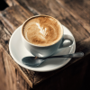 Tasse Cappuccino mit Latte-Art auf Holztisch