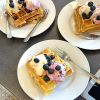 Teller mit Waffeln, Eis, Heidelbeeren und Sahne